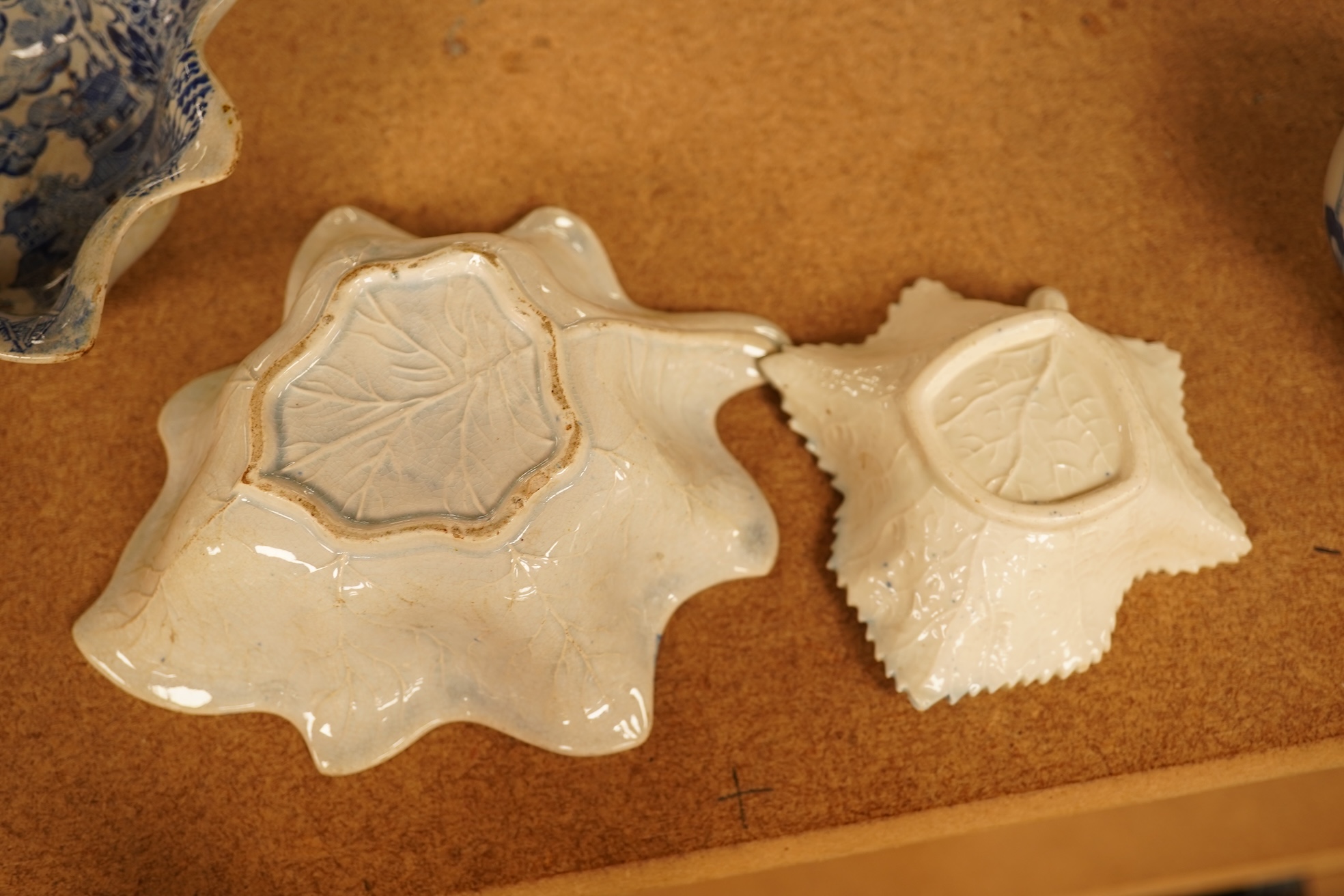 Two late 18th century Worcester or Caughley Cormorant fisherman pattern leaf pickle dishes and two early 19th century blue and white pottery leaf pickle dishes, largest 14.5cm long.